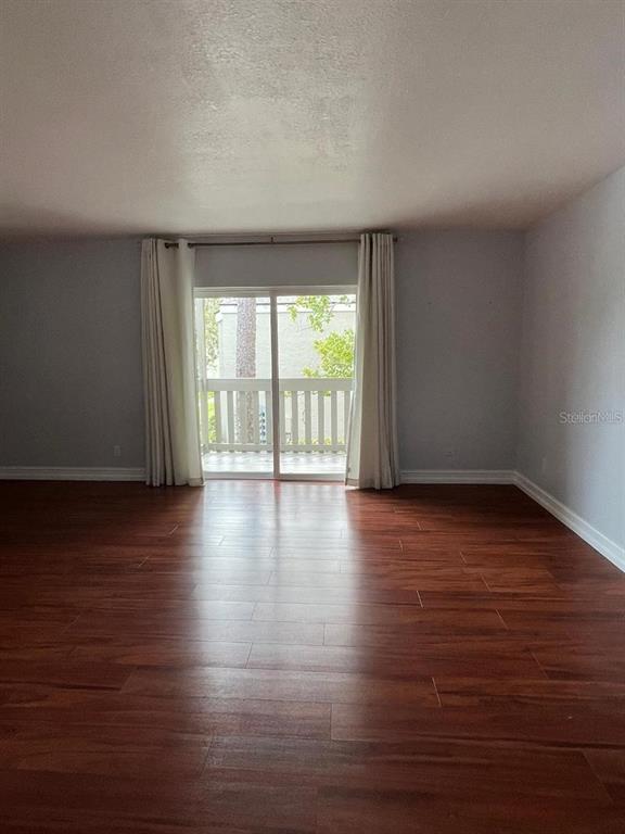 157 Springwood Circle, Unit C Longwood, FL 32750 - Photo 19 of 26 a view of an empty room with wooden floor and a window