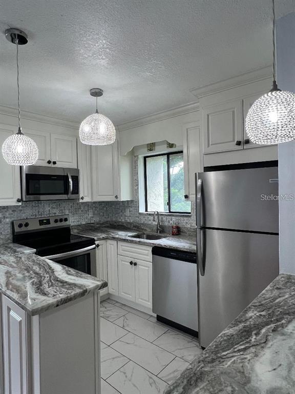 157 Springwood Circle, Unit C Longwood, FL 32750 - Photo 4 of 26 a kitchen with granite countertop a sink a counter and stainless steel appliances
