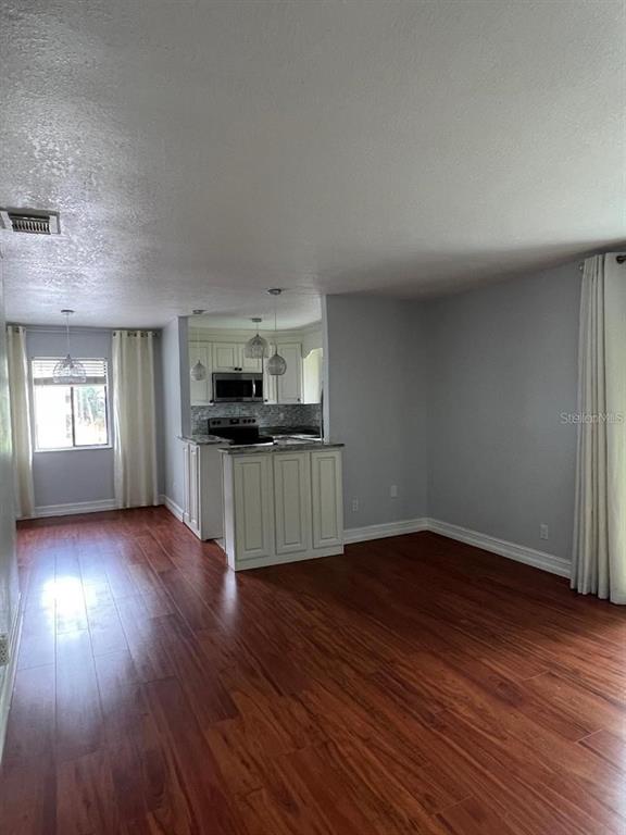 157 Springwood Circle, Unit C Longwood, FL 32750 - Photo 7 of 26 a view of a kitchen with wooden floor and electronic appliances