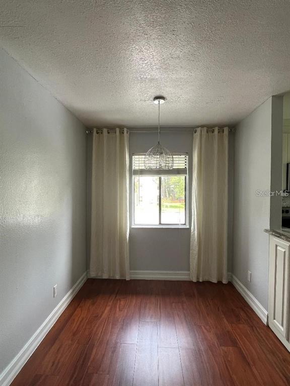 157 Springwood Circle, Unit C Longwood, FL 32750 - Photo 8 of 26 an empty room with wooden floor and windows