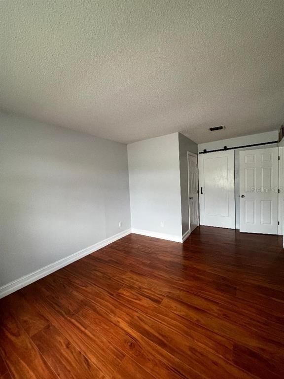 157 Springwood Circle, Unit C Longwood, FL 32750 - Photo 9 of 26 a view of an empty room with wooden floor and a window