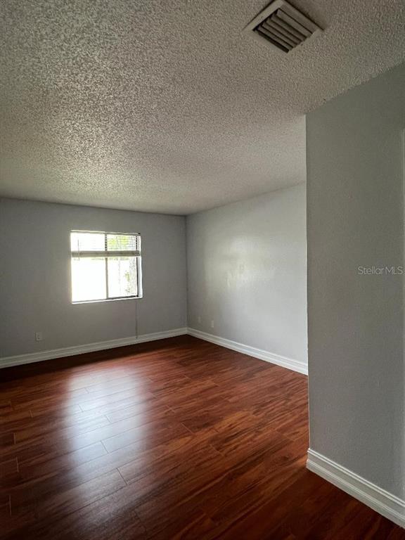157 Springwood Circle, Unit C Longwood, FL 32750 - Photo 10 of 26 a view of an empty room with wooden floor and a window
