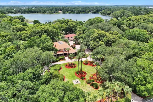 an aerial view of a house with a yard and lake view