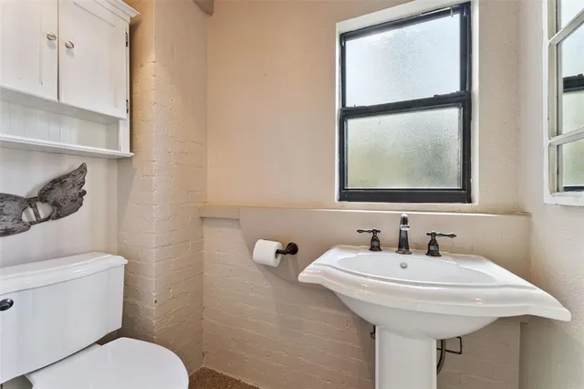 a bathroom with a sink toilet and mirror