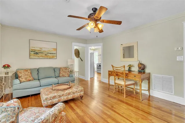 a view of a white house with a yard and large tree