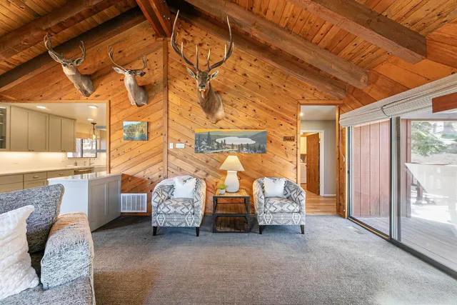 a living room with fireplace furniture and a large window