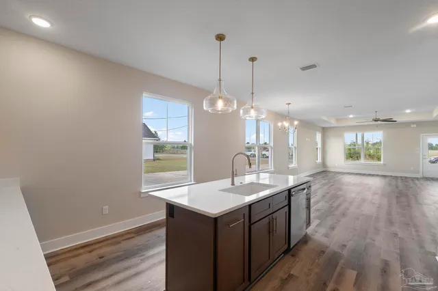 a kitchen with a sink cabinets and wooden floor