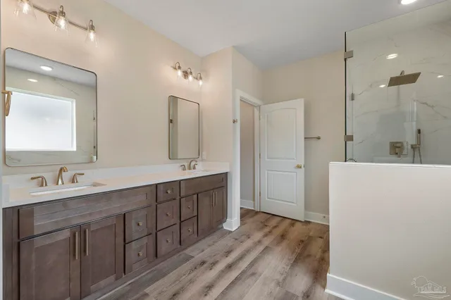 a spacious bathroom with a double vanity sink mirror and shower
