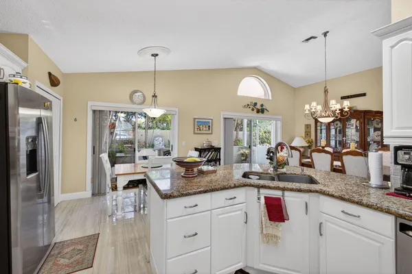 a kitchen with stainless steel appliances granite countertop a sink a stove and a wooden floors