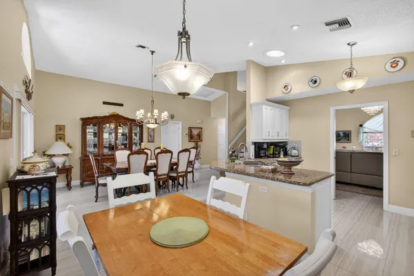 a view of a dining room and livingroom with furniture wooden floor a chandelier