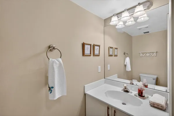 a bathroom with a sink a toilet a mirror and shower