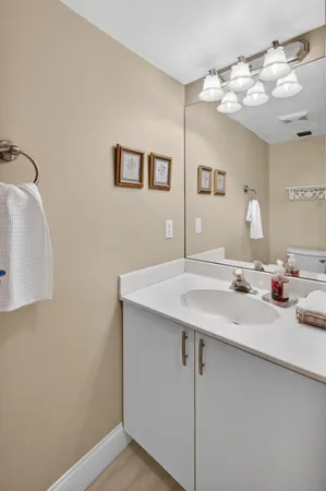 a bathroom with a granite countertop sink a toilet a mirror and shower