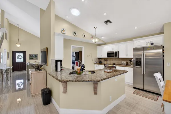 a kitchen with a white cabinets and window