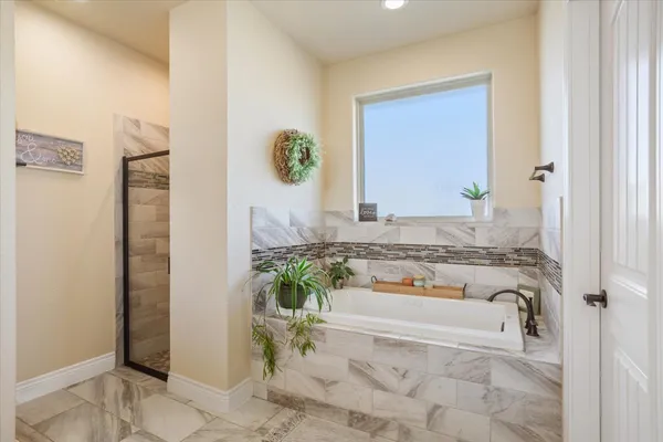 a bathroom with a tub sink and mirror