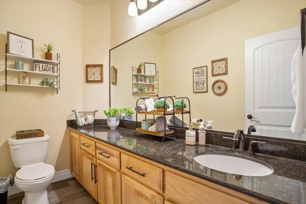 a bathroom with double vanity sinks a toilet and a mirror