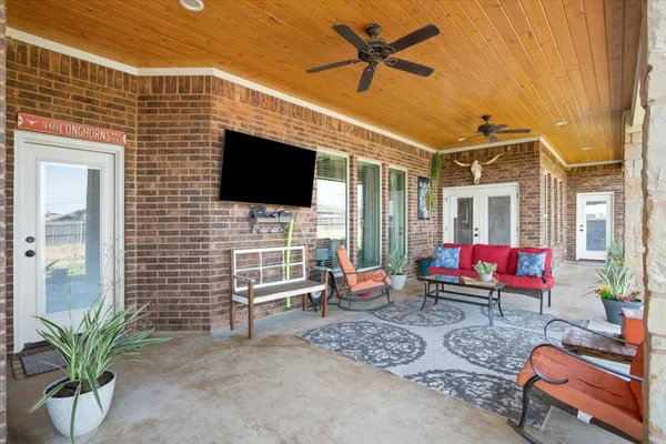 a living room with furniture a flat screen tv and a floor to ceiling window