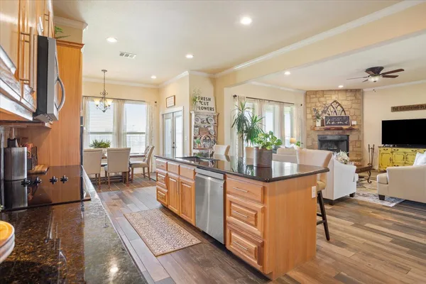 a kitchen with stainless steel appliances kitchen island granite countertop a stove a sink and a refrigerator