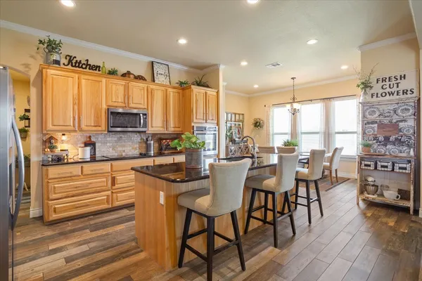 a kitchen with stainless steel appliances granite countertop sink microwave and wooden floor