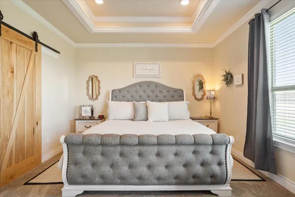 a large bed sitting in a bedroom next to a window