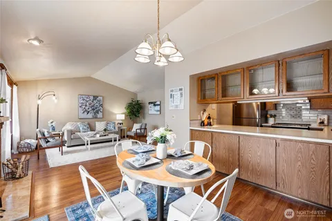 a view of a dining room with furniture a chandelier and wooden floor