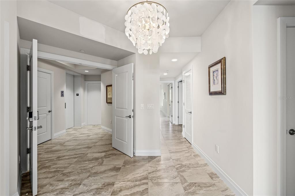 795 Collany Road, Unit 205 St. Petersburg, FL 33715 - Photo 5 of 67 a view of a hallway with wooden floor and a chandelier