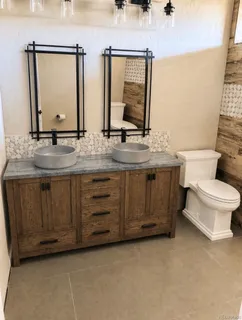 a bathroom with a granite countertop toilet sink and mirror