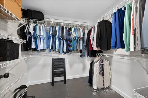 a view of walk in closet with clothes and shoes
