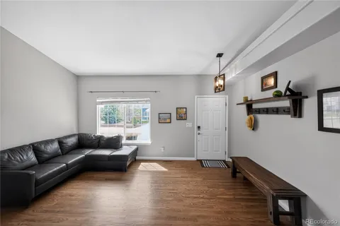 a living room with furniture and wooden floor