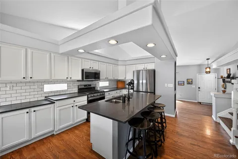a kitchen with granite countertop a sink counter top space and stainless steel appliances