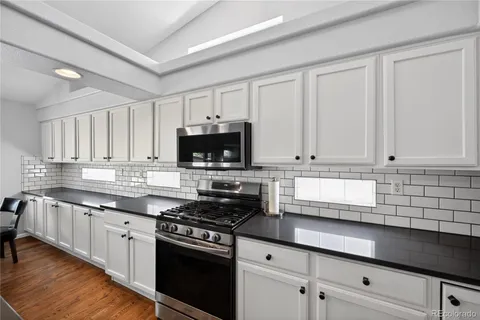 a kitchen with stainless steel appliances granite countertop white cabinets a sink and dishwasher
