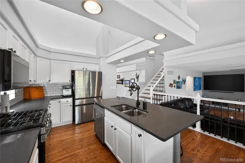 a kitchen with stainless steel appliances granite countertop a sink stove and refrigerator