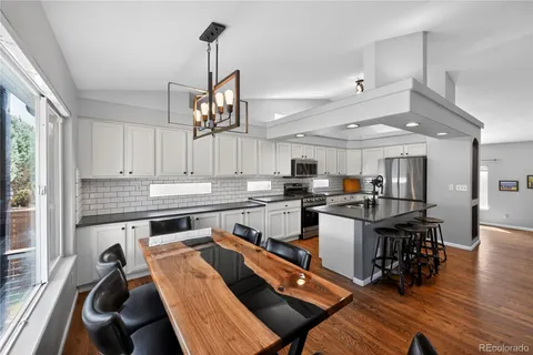 a kitchen with a table chairs stove and cabinets