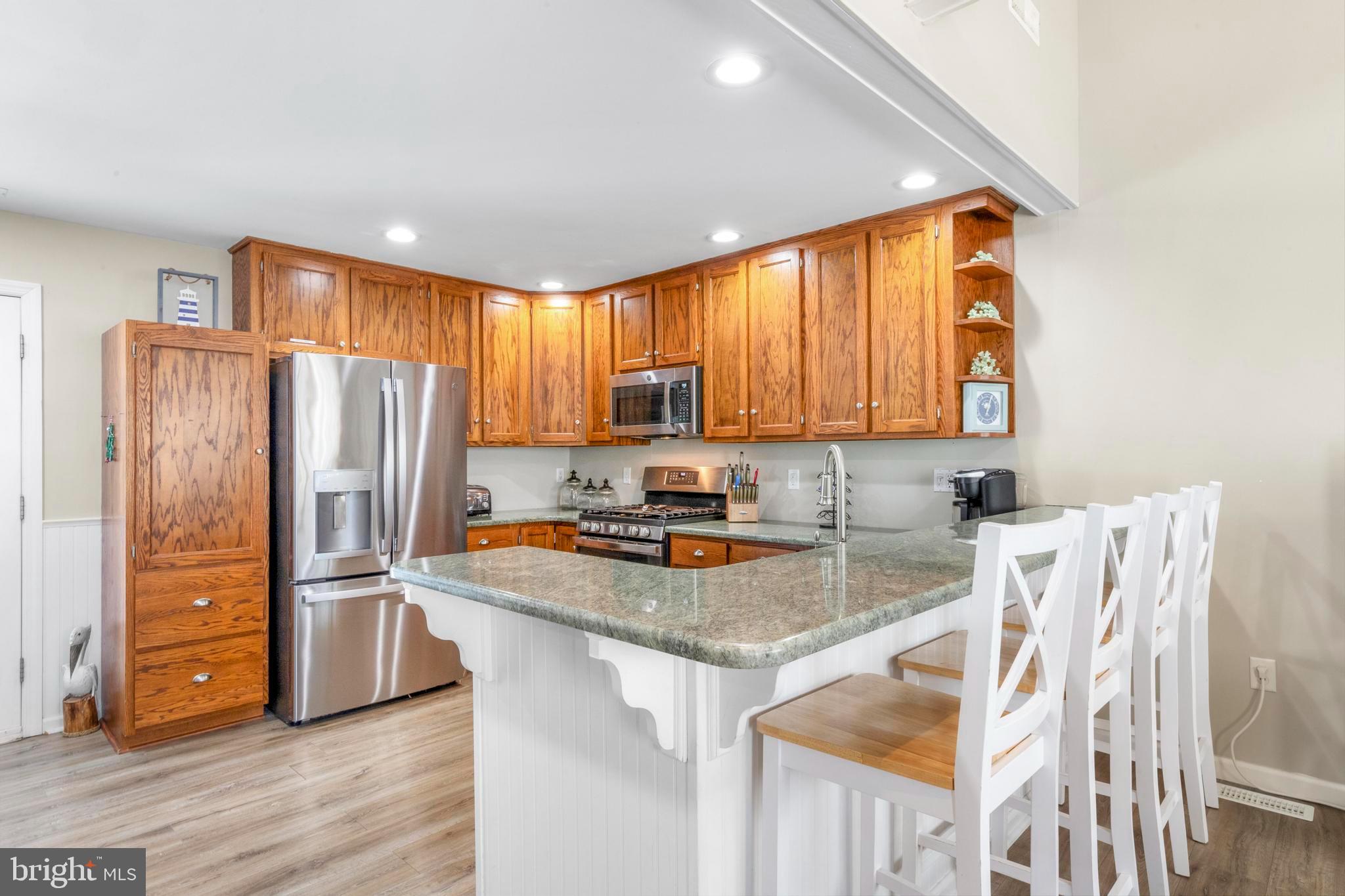 213 West 13th Street Ship Bottom, NJ 08008 - Photo 22 of 70 a kitchen with stainless steel appliances granite countertop a refrigerator a stove a sink and a microwave