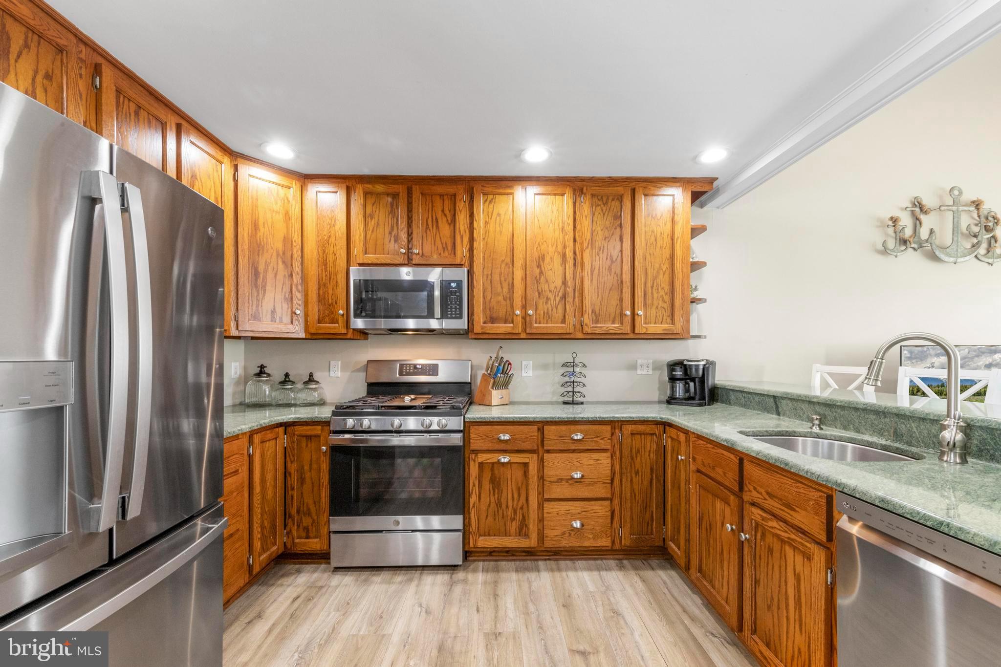 213 West 13th Street Ship Bottom, NJ 08008 - Photo 27 of 70 a kitchen with stainless steel appliances granite countertop a stove a sink dishwasher a refrigerator and a stove top oven