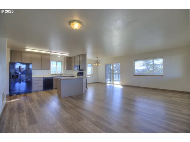 a view of a living room a kitchen and a sink