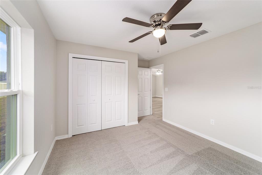 7866 North Manville Road Citrus Springs, FL 34434 - Photo 12 of 19 en empty room with ceiling fan and window