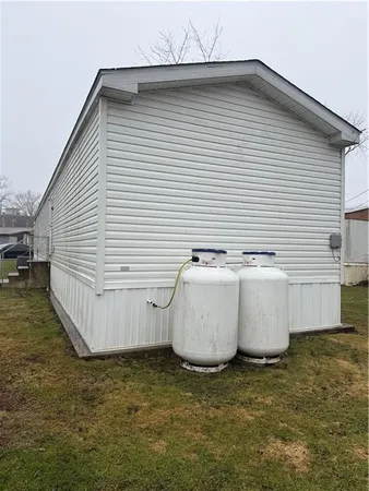 a view of a white house next to a yard