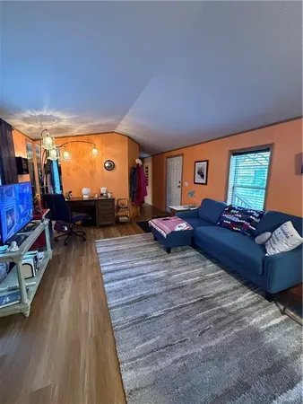 a living room with couches bookshelf and a large window