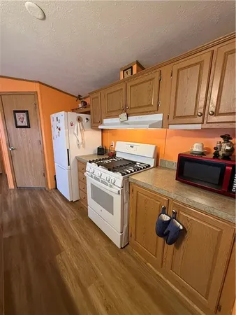 a kitchen with a refrigerator and a stove top oven