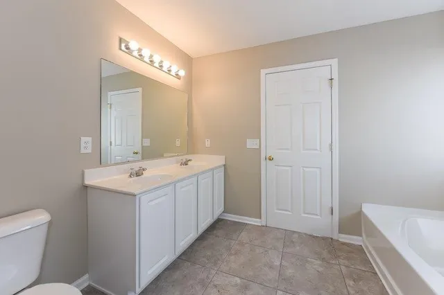 a bathroom with a sink a toilet and a mirror