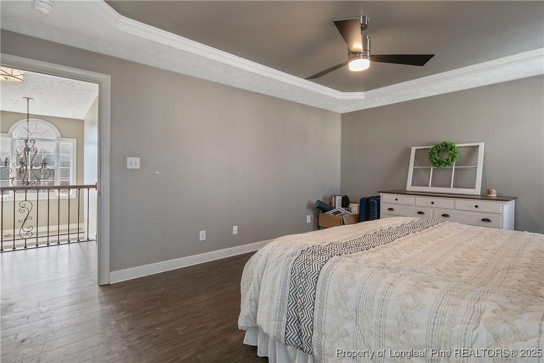 3524 Talus Road Fayetteville, NC 28306 - Photo 31 of 47 a bedroom with a large bed and a chandelier