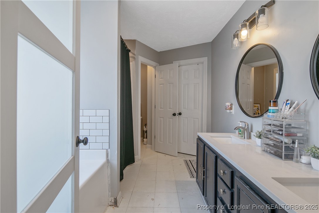 3524 Talus Road Fayetteville, NC 28306 - Photo 32 of 47 a bathroom with a sink a mirror and a shower