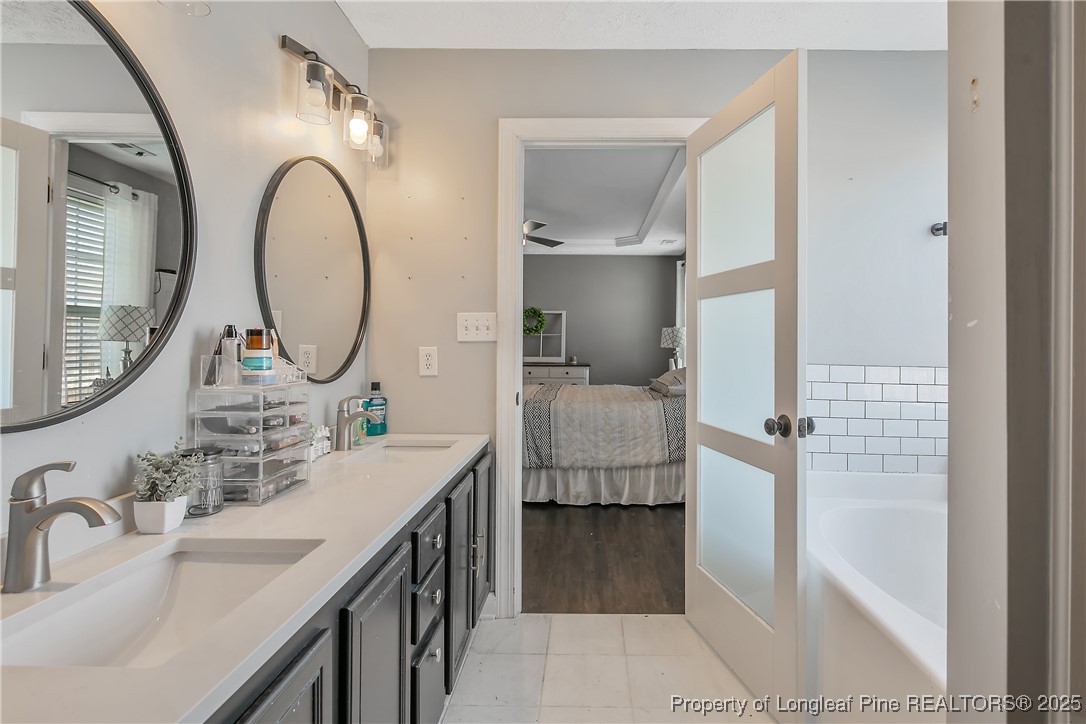 3524 Talus Road Fayetteville, NC 28306 - Photo 33 of 47 a en suite bathroom with a double vanity sink and a mirror