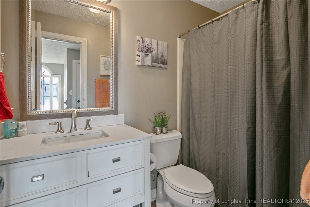 3524 Talus Road Fayetteville, NC 28306 - Photo 40 of 47 a bathroom with a toilet a sink and a mirror
