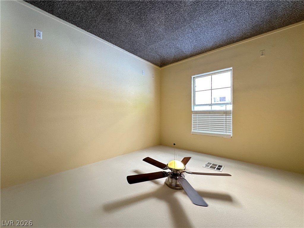 9032 Rutherford Grove Street Las Vegas, NV 89148 - Photo 15 of 24 A well-lit room offers comfort with a ceiling fan for climate control.