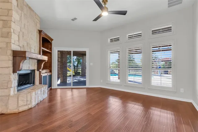 a view of a livingroom with wooden floor and a fireplace