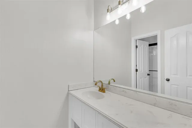 a bathroom with a sink vanity and a mirror