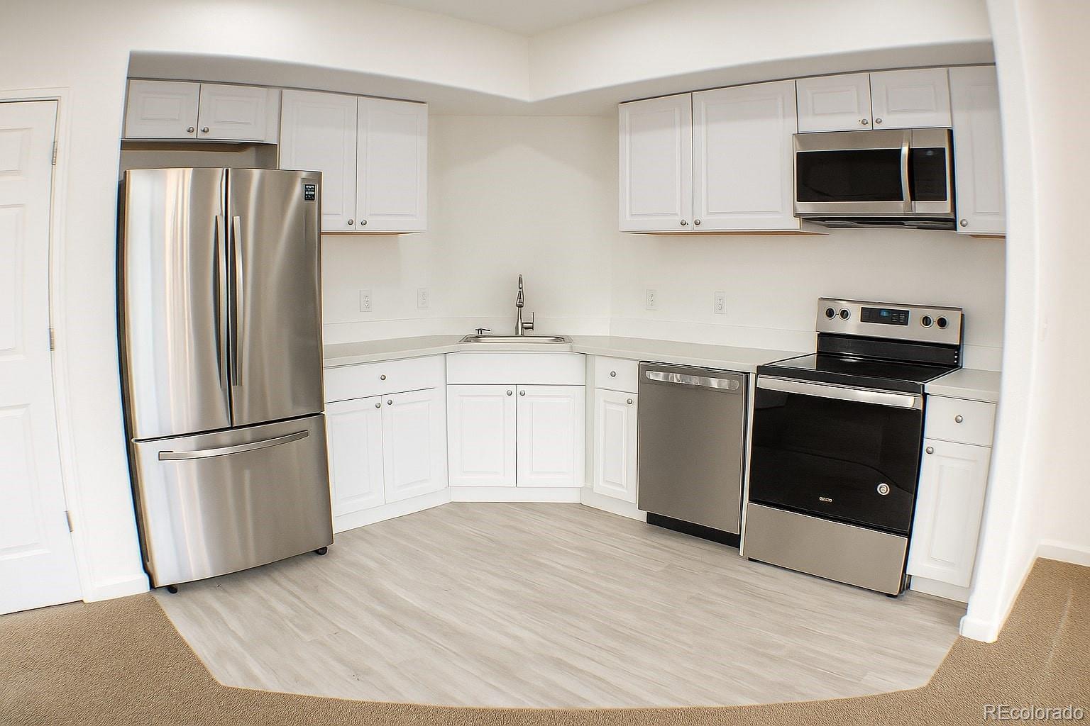 3583 East Uintah Street, Unit 102 Colorado Springs, CO 80909 - Photo 5 of 23 a kitchen with a refrigerator stove and microwave