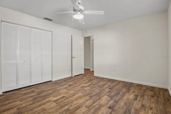 a view of an empty room with wooden floor