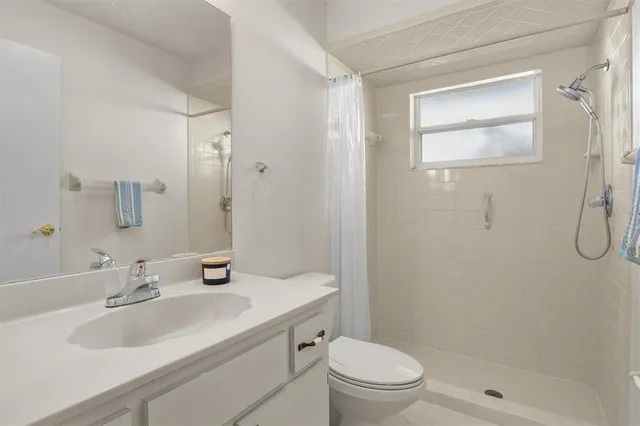 a bathroom with a sink toilet vanity and shower